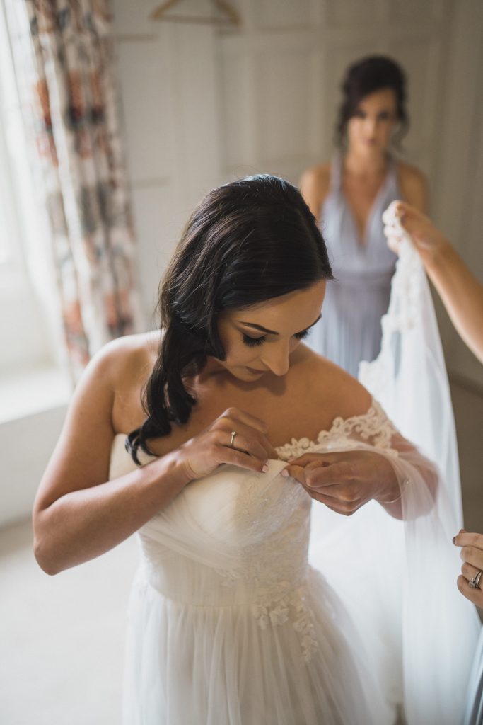 bride attaching wedding dress Elmore court photography