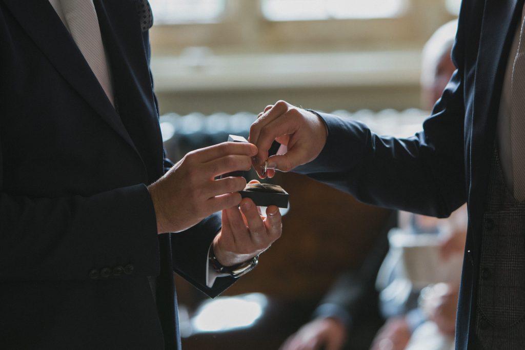 groom taking wedding band Elmore court photography