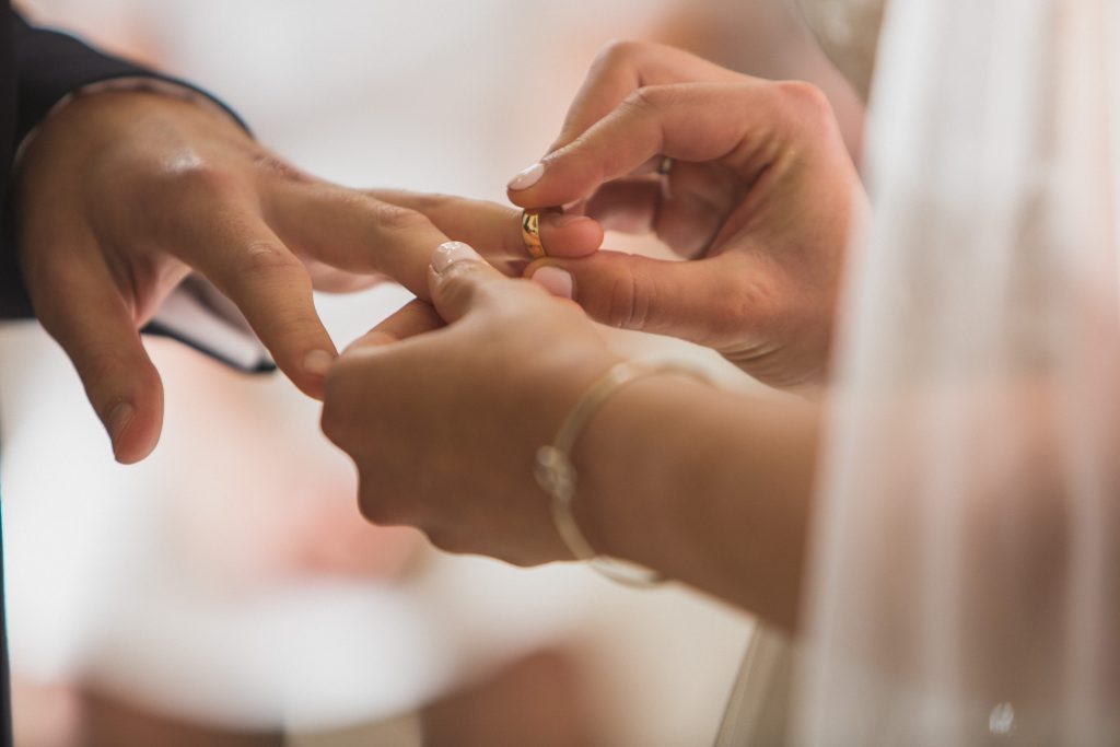 bride putting on grooms ring Elmore court wedding photographer