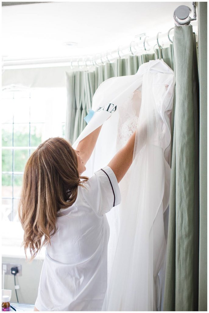 Bride uncovering Berta wedding dress Barnsley house wedding photographer